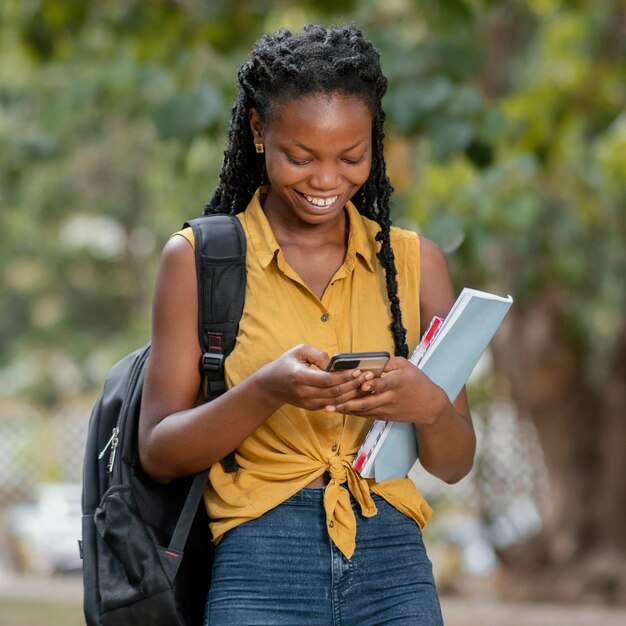 Medium shot smiley woman with smartphone