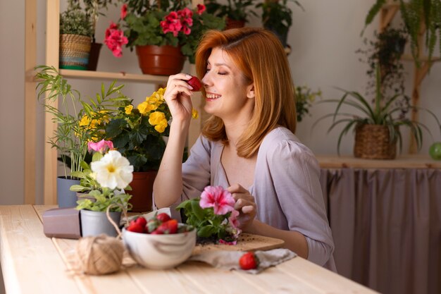 Medium shot smiley woman with strawberry