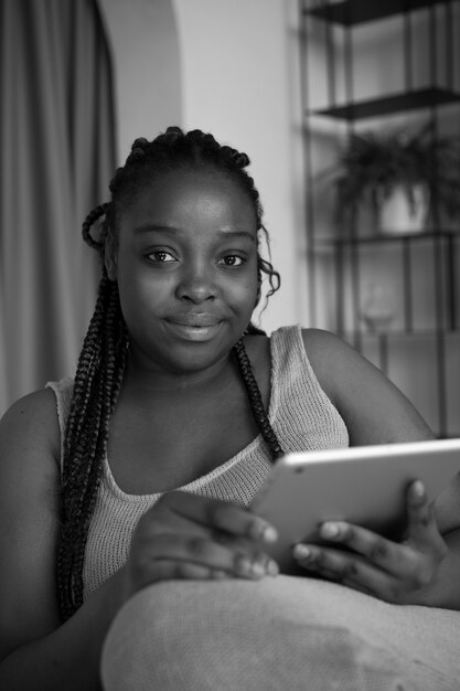 Medium shot smiley woman with tablet at home