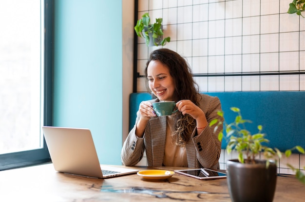 Medium shot smiley woman with tablet