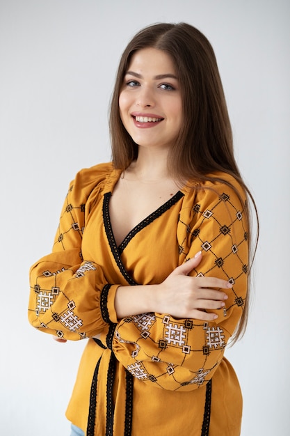 Donna sorridente di colpo medio con camicia ucraina