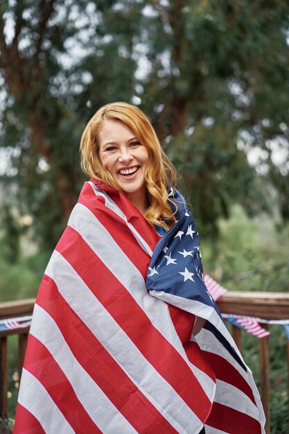 미국 국기와 함께 중간 샷 웃는 여자