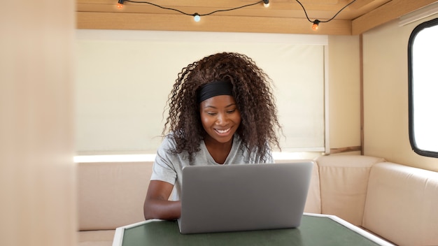 Medium shot smiley woman working on laptop