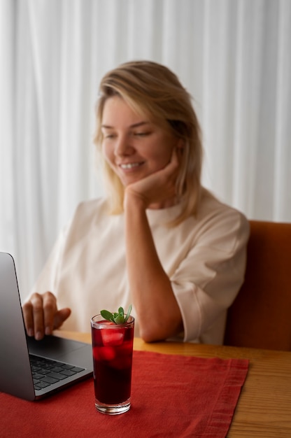 Free photo medium shot smiley woman working on laptop