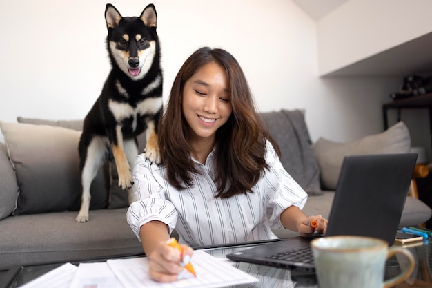 犬と一緒に働くミディアムショットの笑顔の女性