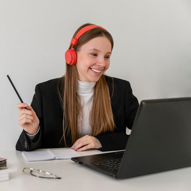 Medium shot smiley woman working with laptop