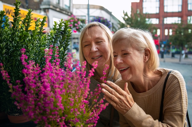 Foto gratuita donne sorridenti del colpo medio che esaminano i fiori