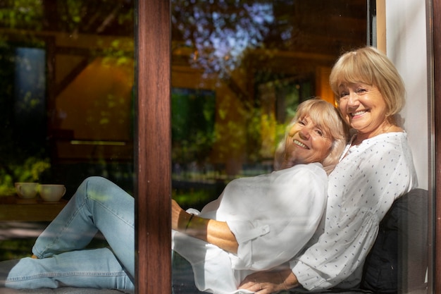 Medium shot smiley women sitting together