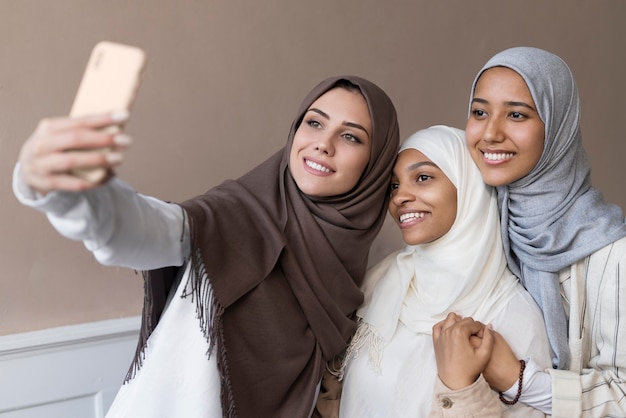 Medium shot smiley women taking selfie