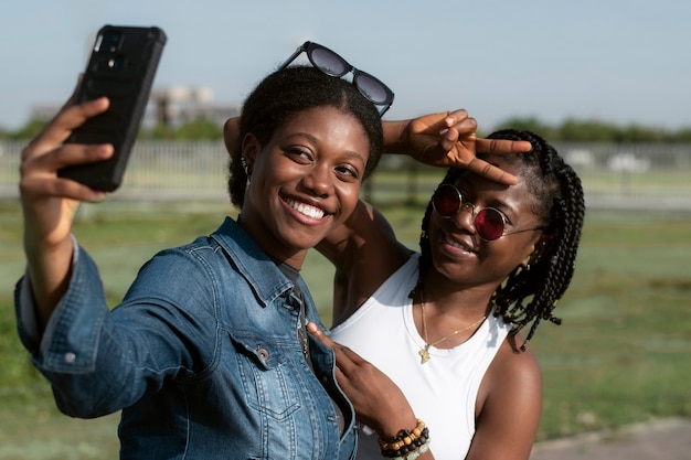 Medium shot smiley women taking selfie