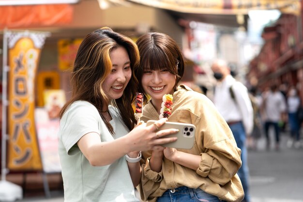 Medium shot smiley women taking selfie