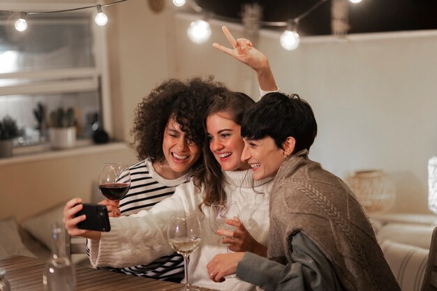 Medium shot smiley women taking selfie