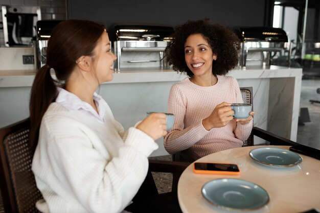 コーヒーカップとミディアムショットのスマイリー女性