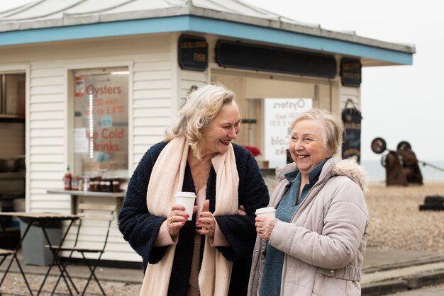 Medium shot smiley women with coffee cups