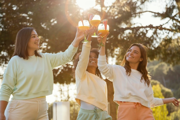 Free photo medium shot smiley women with drinks