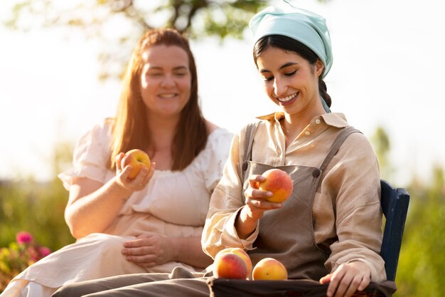 Medium shot smiley women with fruits