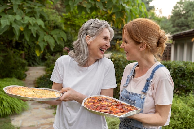 Medium shot smiley women with pizza