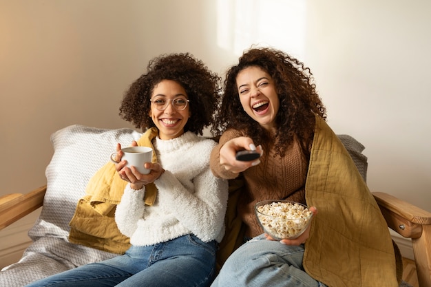 Free photo medium shot smiley women with remote