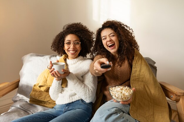 Medium shot smiley women with remote