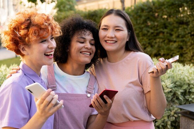 Medium shot smiley women with smartphones