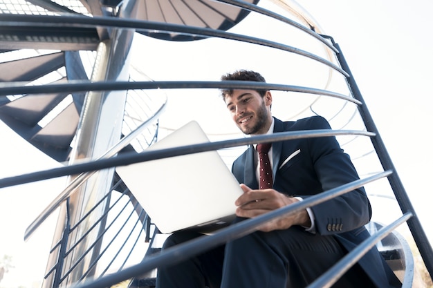 Free photo medium shot smiley working man on the stairs