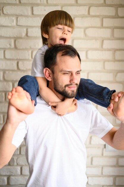 Medium shot son on father's shoulders