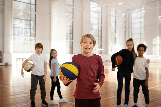 Бесплатное фото Спортивные дети среднего роста в спортзале