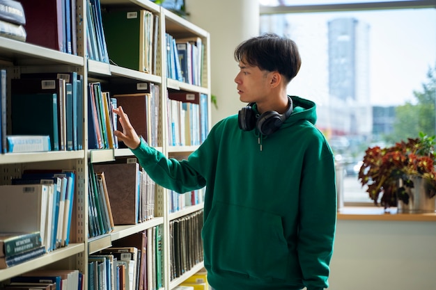 Foto gratuita studente di tiro medio che cerca un libro