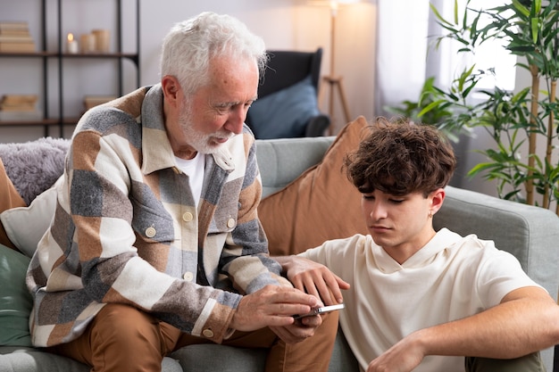 Medium shot teen and man with smartphone