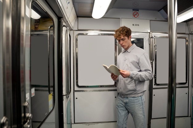 Подросток среднего размера читает в общественном транспорте