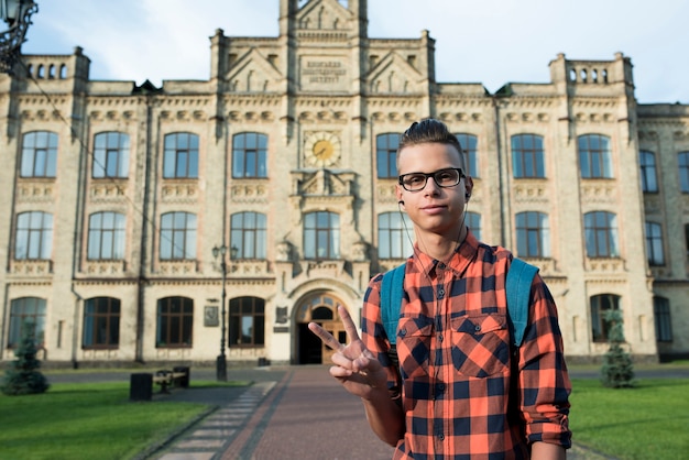 Medium shot teenage boy showing peace sign