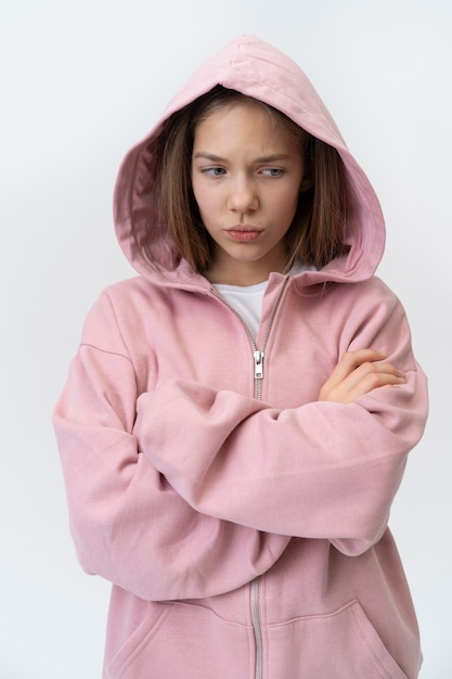 Foto gratuita adolescente di tiro medio che indossa una felpa con cappuccio