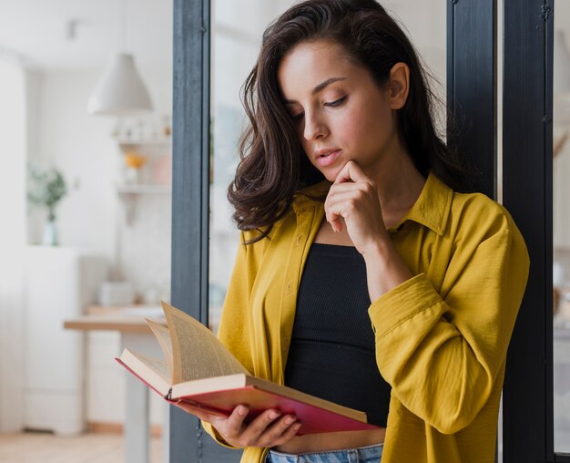 Medium shot thinking girl with book