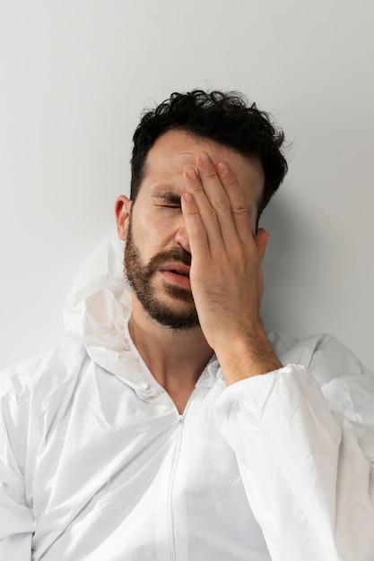 Foto gratuita medico stanco del tiro medio che indossa una tuta ignifuga