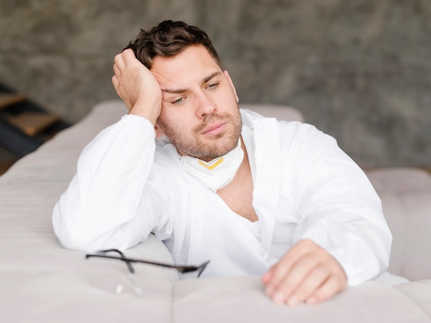 Medium shot tired man sitting on sofa