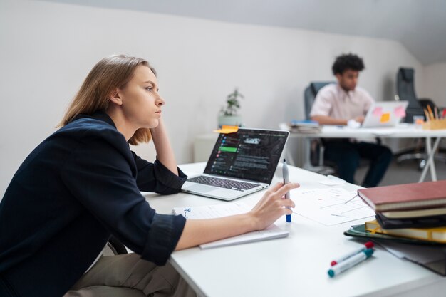 Medium shot tired woman at desk