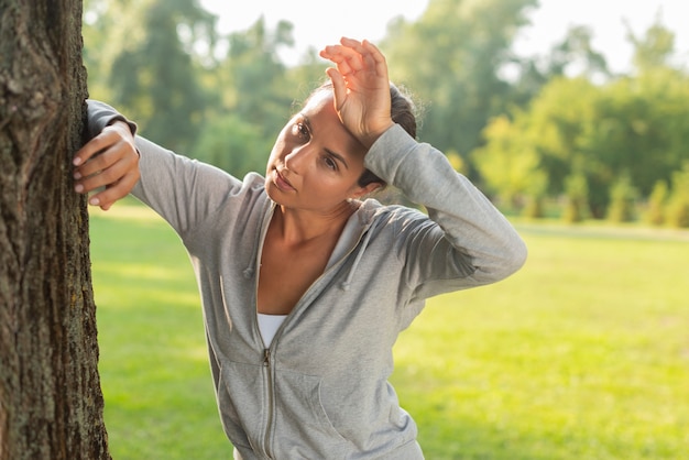 Medium shot tired woman near tree