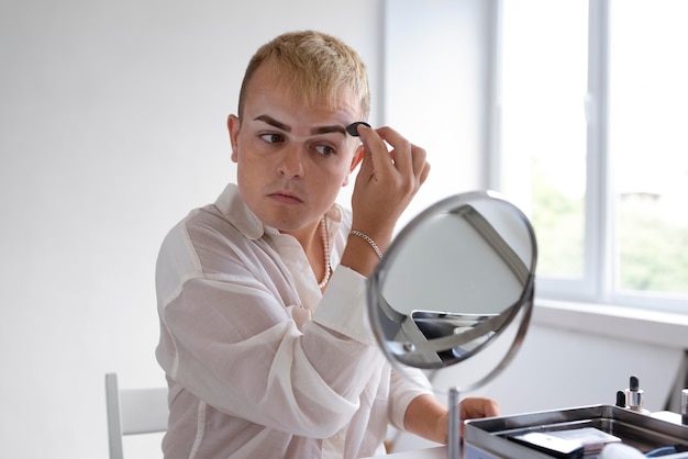 Medium shot transgender looking in the mirror