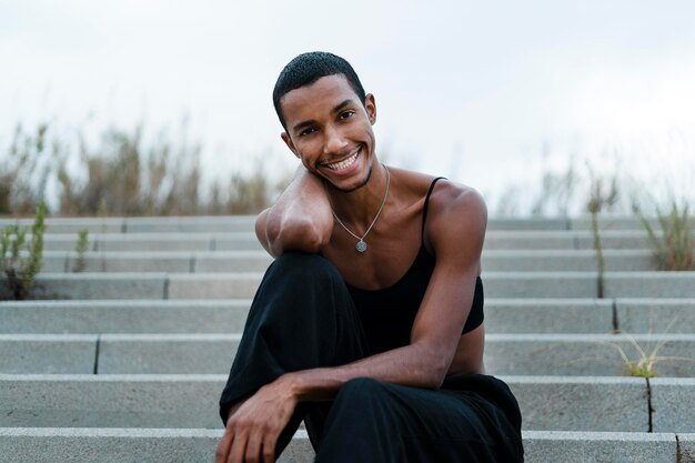 Medium shot transgender sitting on stairs