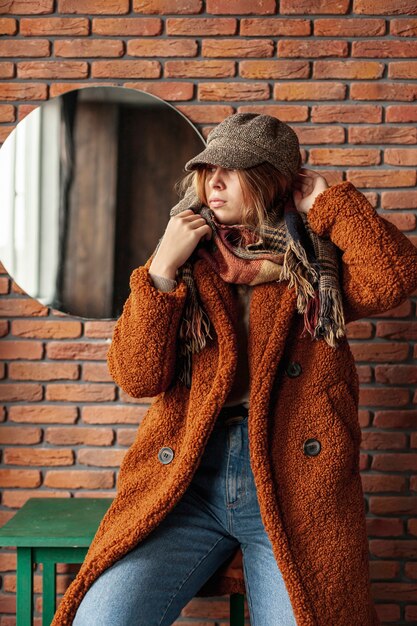 Medium shot trendy girl with coat posing