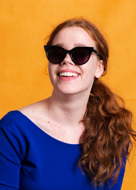 Medium shot trendy woman with sunglasses and wide smile