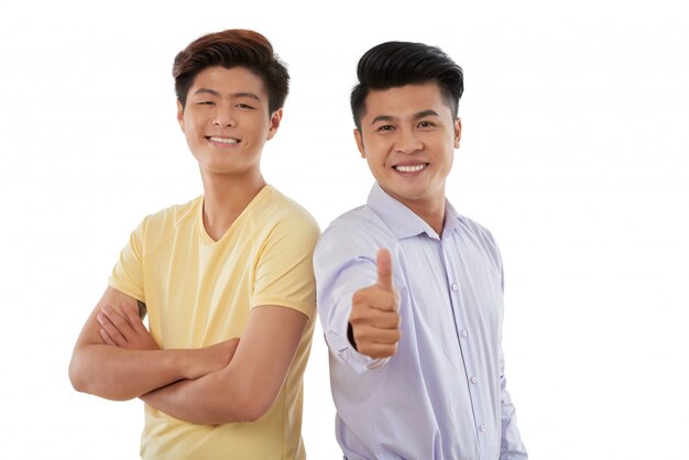 Medium shot of two guys standing shoulder to shoulder and gesturing at camera