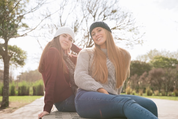 Medium shot of two smiling women sitting on a bench