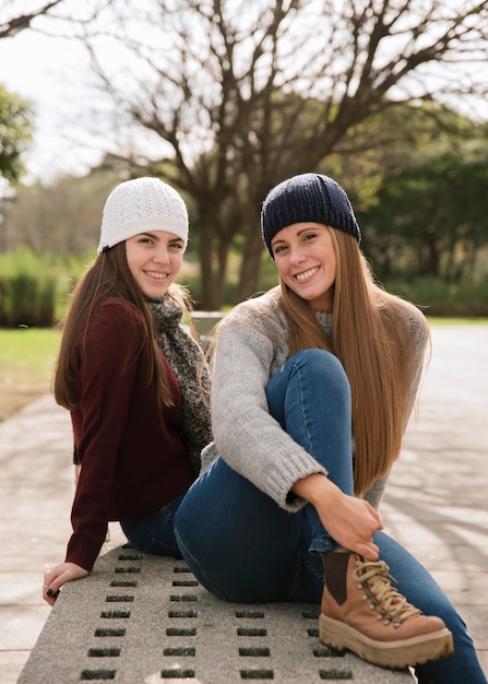 Medium shot of two smiling women sitting on a bench