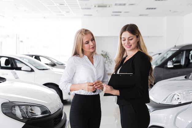 Medium shot of two women looking at a clipboard