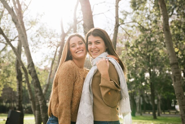 Medium shot of two women smiling in the park