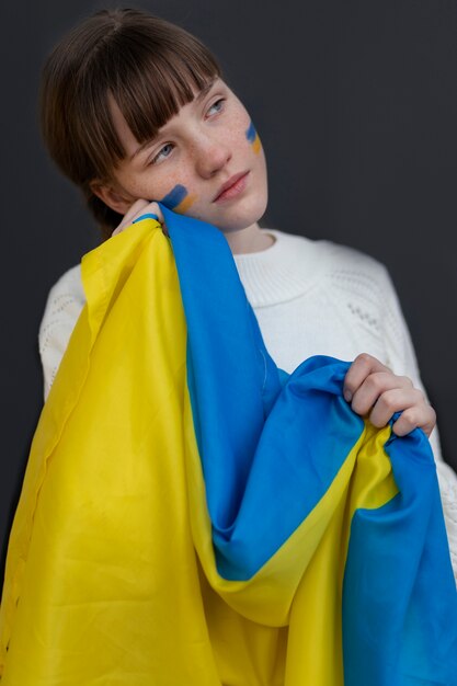 旗を保持しているミディアムショットウクライナの女の子