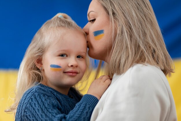 Medium shot ukranian mother kissing child