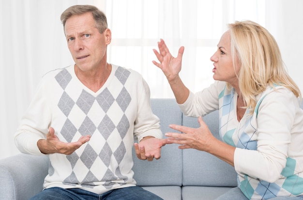 Medium shot upset couple arguing on the couch