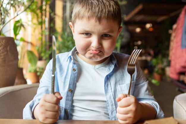 Medium shot upset kid with cutlery